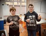 Zwei Schüler der 5. Klasse freuen sich über einen Becher Joghurt im Hauswirtschaftsraum