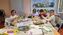 Die Schüler und Schülerinnen der Klasse 4 arbeiten an einem eigenen Hundertwasserhaus. Sie kleben, basteln und malen  mit verschiedenen Materialien. Das Ergebnis präsentieren sie im Schulgebäude.